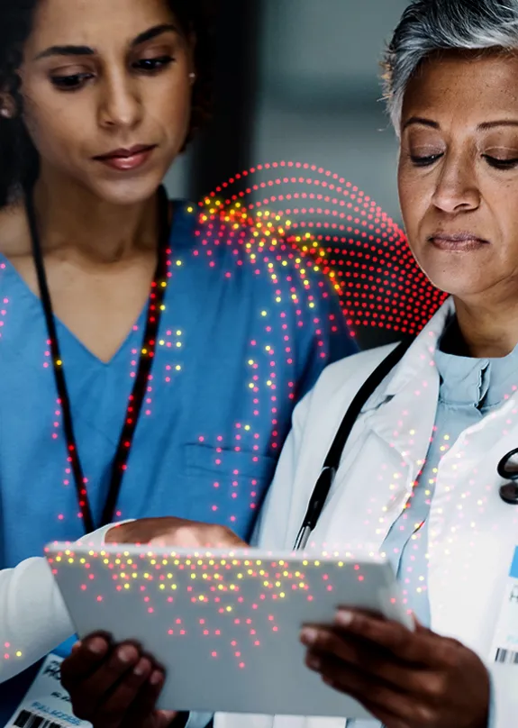 Two female doctors looking at a computer tablet 